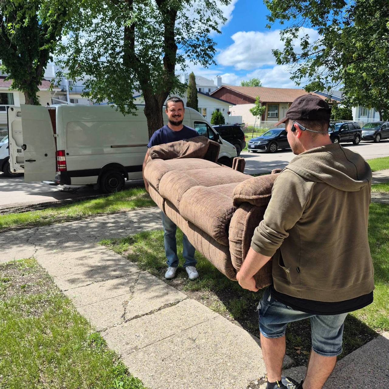 Prairie Spotless movers carrying a couch on a Winnipeg move